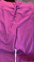 Back view of purple ribbed drawstring pants showing waistband and drawstring