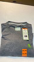 Folded grey John Deere long sleeve T-shirt with tags visible