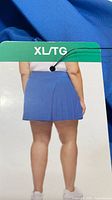 Tag showing rear view of blue pleated skort and XL/TG size