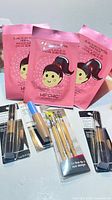 Front view showing three Hip Chic hair masks, two eyeliner sets, two CoverGirl concealers, brush set