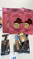 Front view showing three Hip Chic hair mask pouches and five sealed makeup items