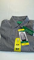 Folded striped dress shirt with tags visible