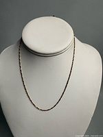 Full view of gold rope chain on display bust