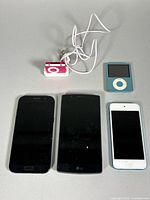 Group shot of three iPods, two smartphones, and Shuffle charger cable