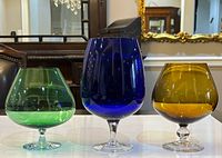 Front view of all three colored glass snifters