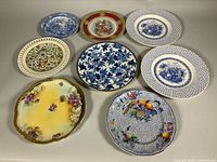 All eight assorted porcelain plates laid out