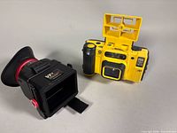 Front three-quarter view of Minolta Weathermatic Dual 35 camera beside CarrySpeed VF-4 viewfinder