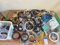 Overview of assorted coiled and bagged cables spread on table