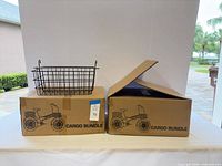 Two sealed cargo bundle boxes, one open showing large wire basket on top