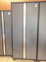 Front view of tall gray/charcoal metal cabinet with doors closed