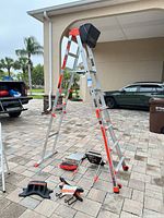 Full view ladder set in A-frame with accessories on ground