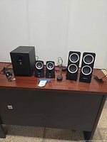 Full set on desk showing subwoofer, Z313 satellites, Z200 pair, remote, cables