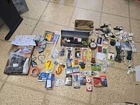 Top-down view of entire lot displaying TV mount, toolbox, tapes, hardware packs, cords and instrument