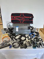 Overview of bundle including keyboards, mice, cables, power strip, adapters, Netgear switch, Thermaltake case