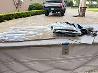 Full kit components in plastic on table including wood shelf panels, metal frames and hardware bags