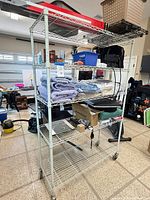 Full view of shelving unit with five shelves and casters