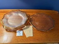 Stack of six gold-trimmed glass plates with three warranty certificates