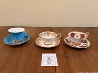 Three bone china teacup and saucer sets displayed side-by-side