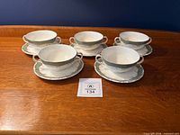 Set of five soup bowls on saucers displayed