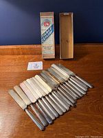 Full lot: 18 knives laid out with branded box