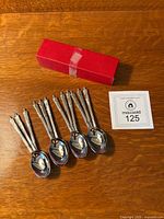 All 12 spoons laid out with box and lot card visible