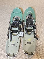 Top view of both Tubbs snowshoes showing deck colour, logo, size tag, bindings