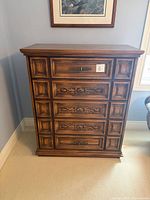 Front view of dresser showing five carved drawers and overall style