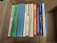 Row of 10 book spines inside cardboard box