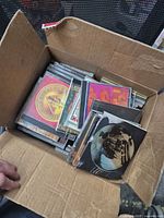 Top view of box filled with CDs showing variety of album covers