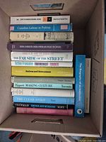 Entire stack of approximately 14 books inside carton