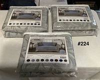 Three packaged Chiara Rose sofa covers displayed
