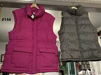 Front view of both vests hanging, showing colors, style and size comparison