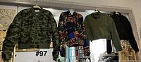Four jackets hanging: camouflage, multicolor, green, black