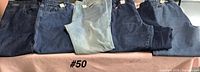 Five pairs jeans laid out on table
