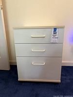 Front view showing three drawers and caster base