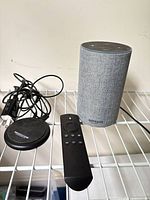 Echo speaker, Dot device, remote, power adapter on shelf