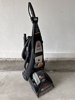 Front full view of Bissell ProHeat 7950 upright carpet cleaner with attached hose