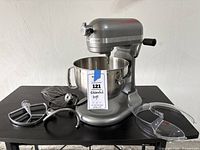Mixer with bowl and all four attachments arranged on table