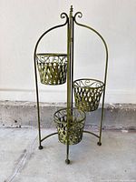 Front view of tall metal plant stand showing three lattice baskets