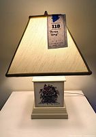 Full lamp illuminated showing square shade and base with pansy panel