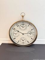 Front view showing full clock face with five dials and antique brass frame