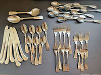 Full view of assorted hammered flatware laid out by type