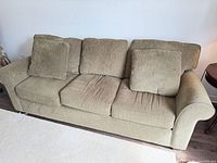 Front view of beige and brown 3-seater sofa with cushions
