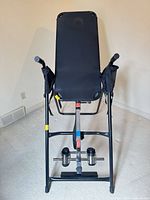 Front view showing padded backrest, handles, ankle holders