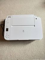 Top view of white Canon PIXMA TS-series all-in-one printer showing control panel and flatbed lid