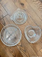 Overview of all three clear glass pieces: citrus reamer, divided dish, heart dish