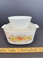 Casserole with lid and bowl stacked, ruler for scale