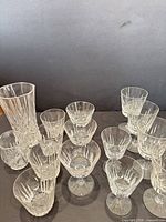 Group shot of thirteen crystal glasses with vase