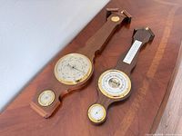 Pair of wood wall weather stations showing overall design and size difference