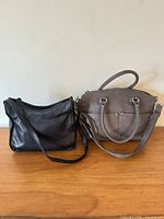 Black and grey bags side by side on tabletop